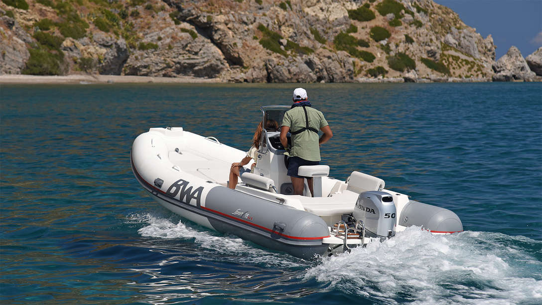 Båt med BF50-motor, använd av modell, kustmiljö.